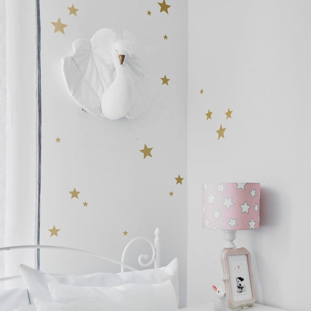 bold arrangement of gold star stickers in various sizes on a dark wall