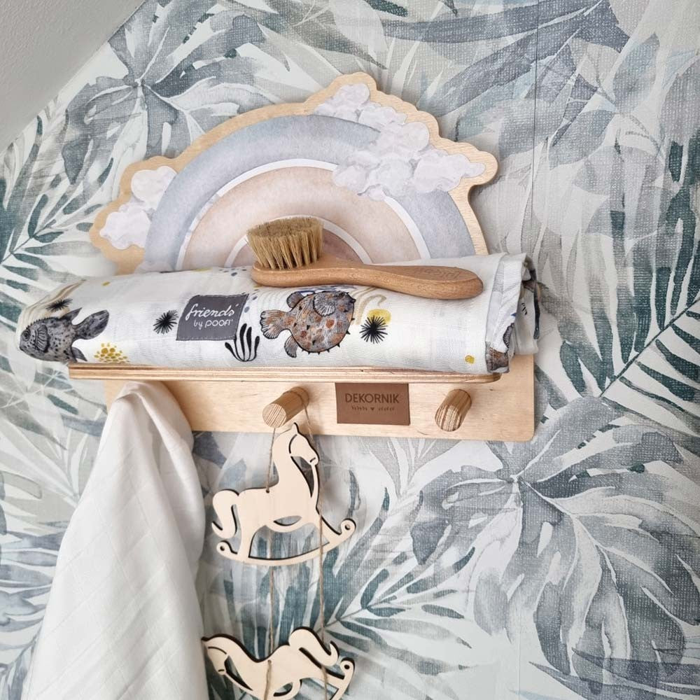 softly lit blue rainbow mini shelf with a whimsical dinosaur sticker, mounted on a gentle nursery wall