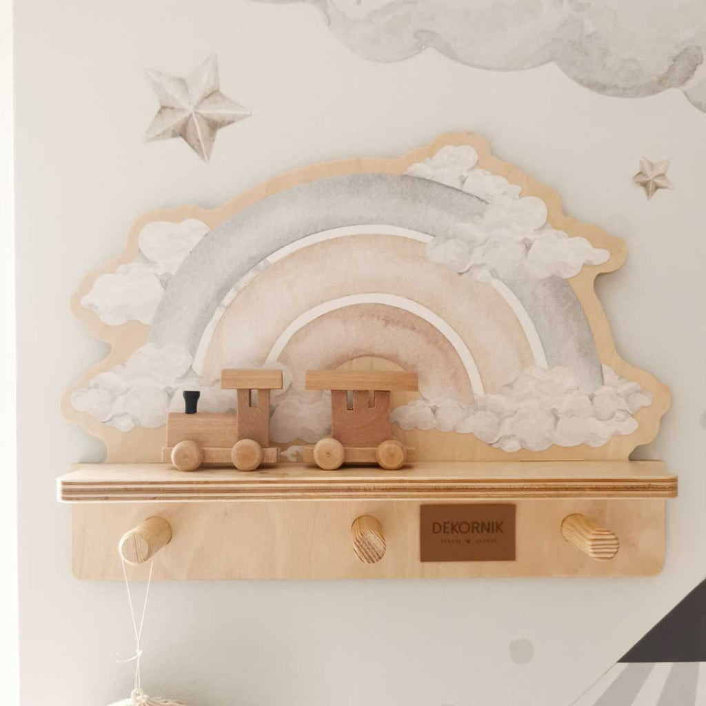 a playful blue rainbow wall shelf with a dinosaur sticker, shown in a bright kids room with soft morning light