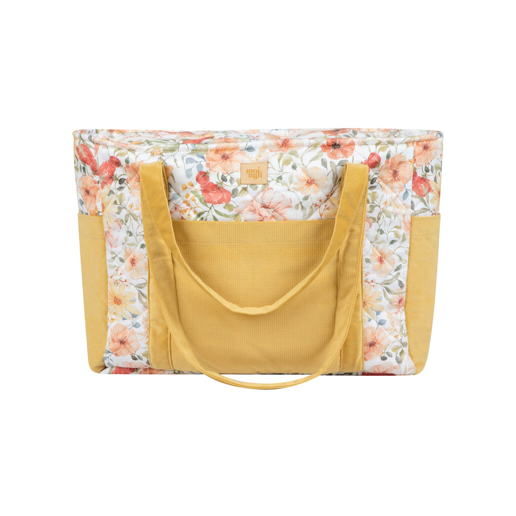 soft velvet weekender bag with floral pattern held gently in morning light