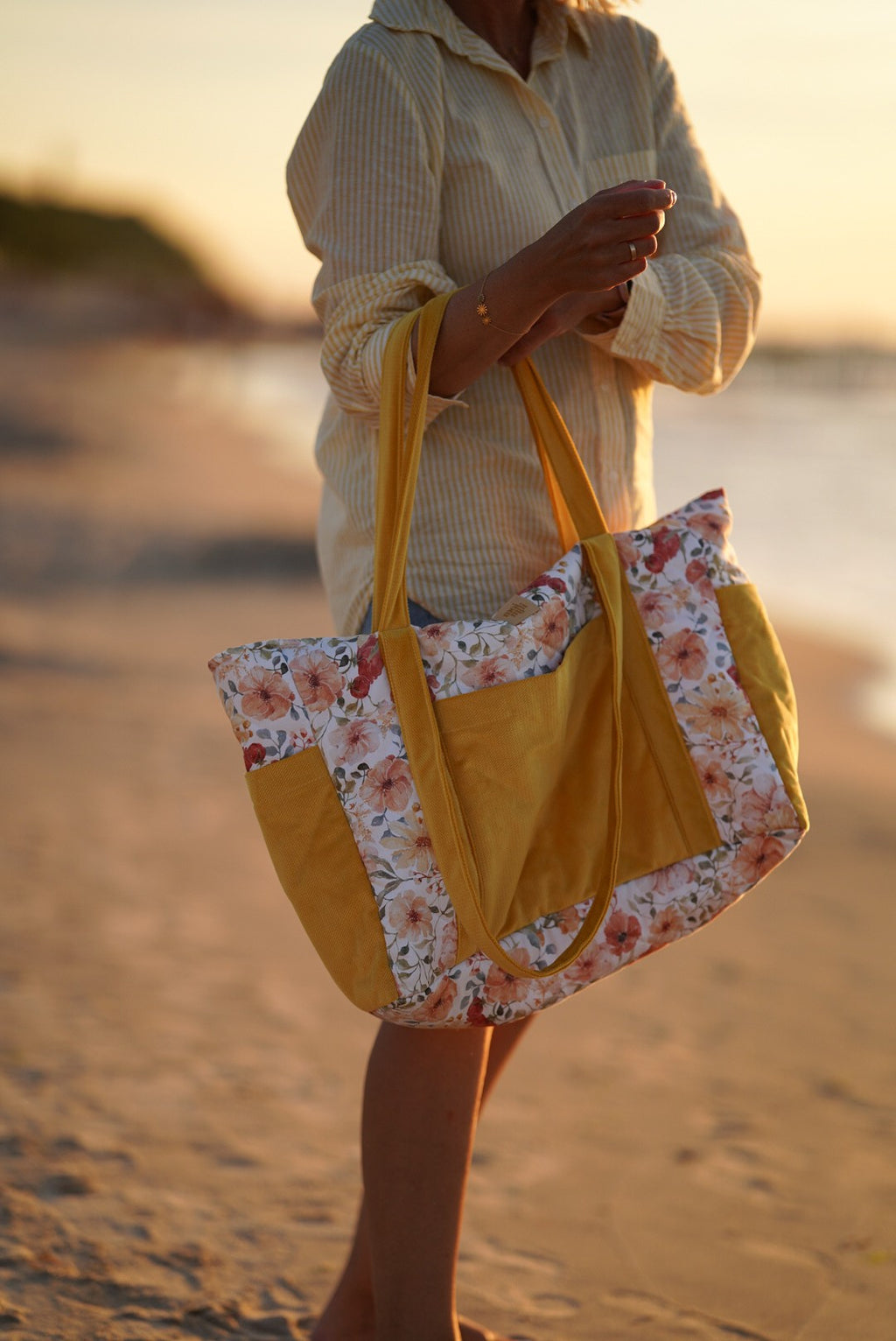 playful floral weekender bag with multiple pockets, held by a smiling mom on an adventure