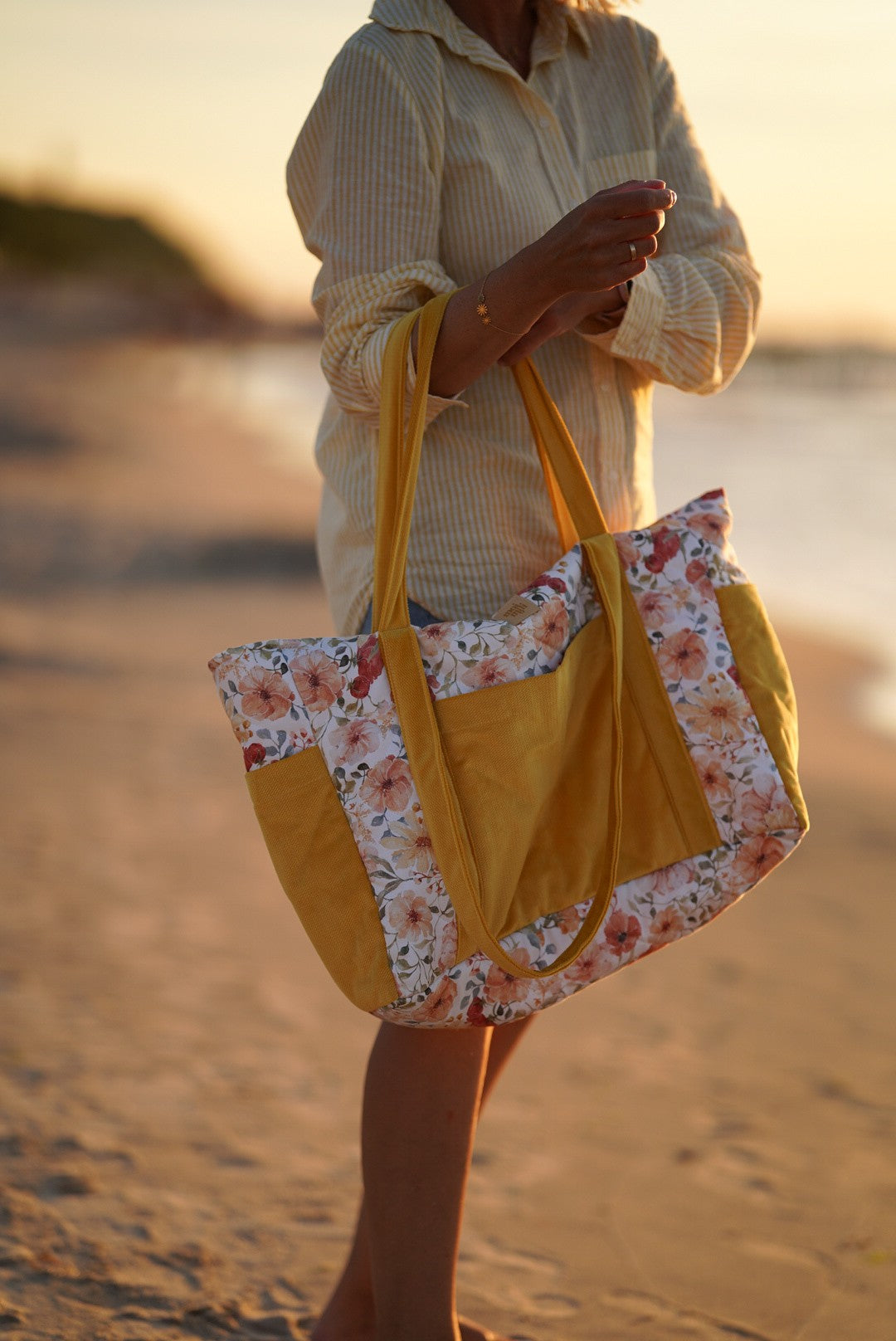 playful floral weekender bag with multiple pockets, held by a smiling mom on an adventure