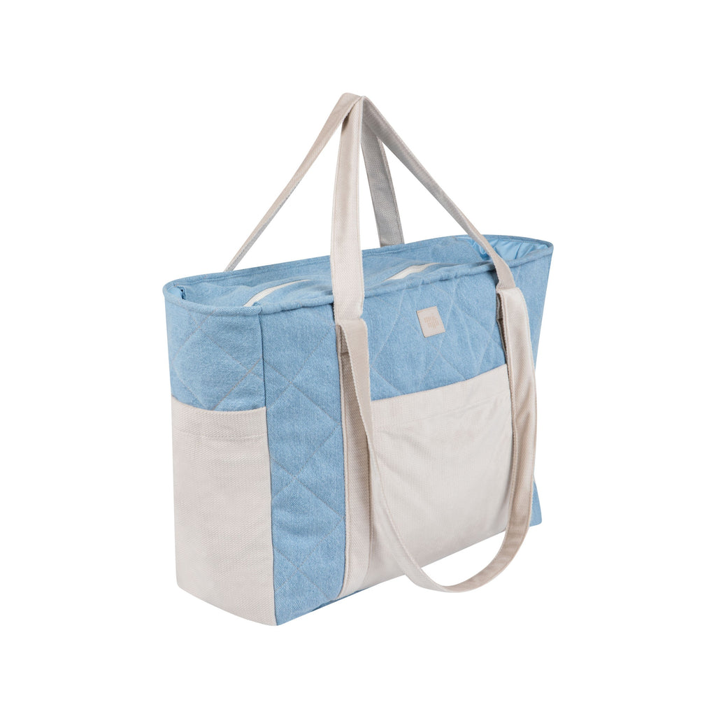 soft denim weekender bag with cozy velvet details, resting on a comforting linen background