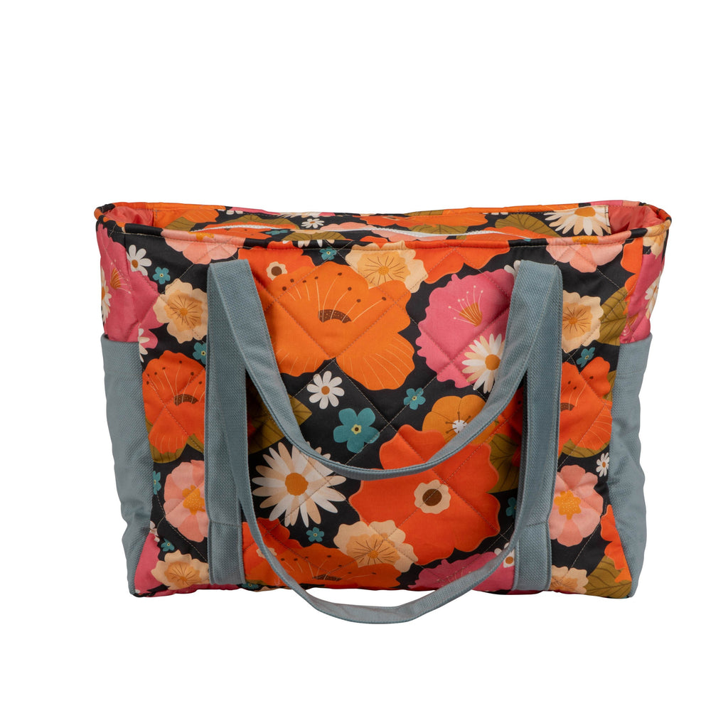 mom's picnic weekender bag with floral print open on a park bench showing its spacious interior and pockets