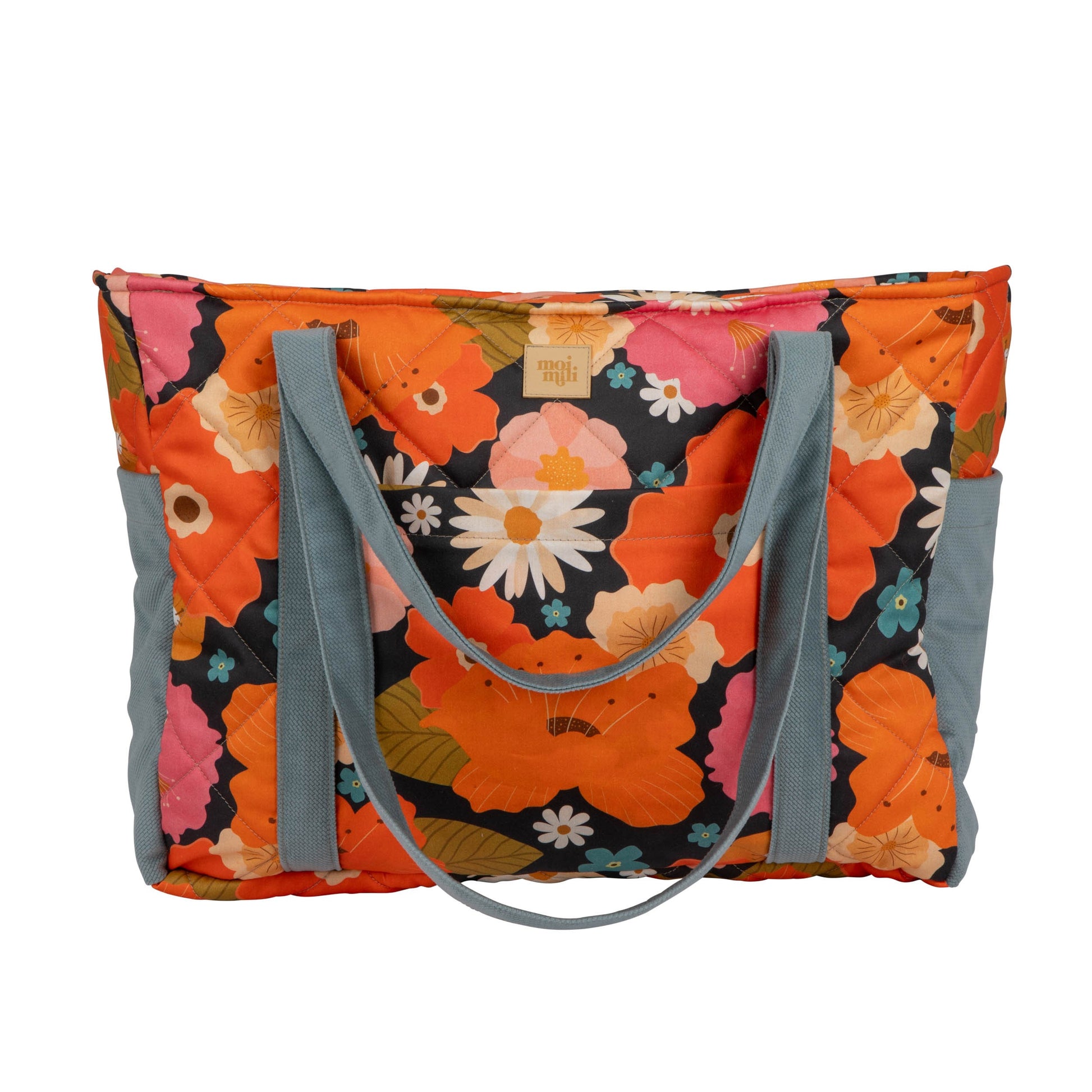 mom weekender bag with floral picnic print open on a park bench showing its inner waterproof pockets
