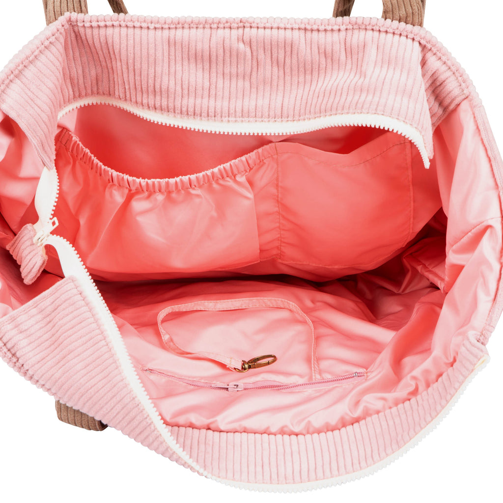 pink velvet weekender bag open to show its six practical pockets and waterproof lining