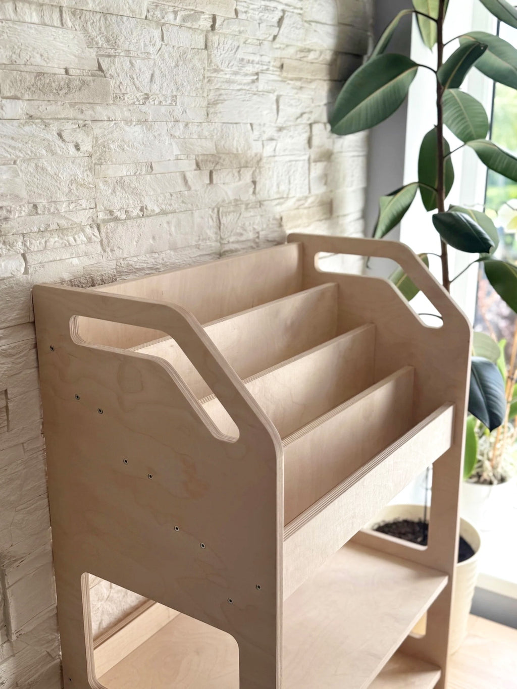 montessori bookshelf in a bright playroom with a soft toy peeking from the bottom cubby