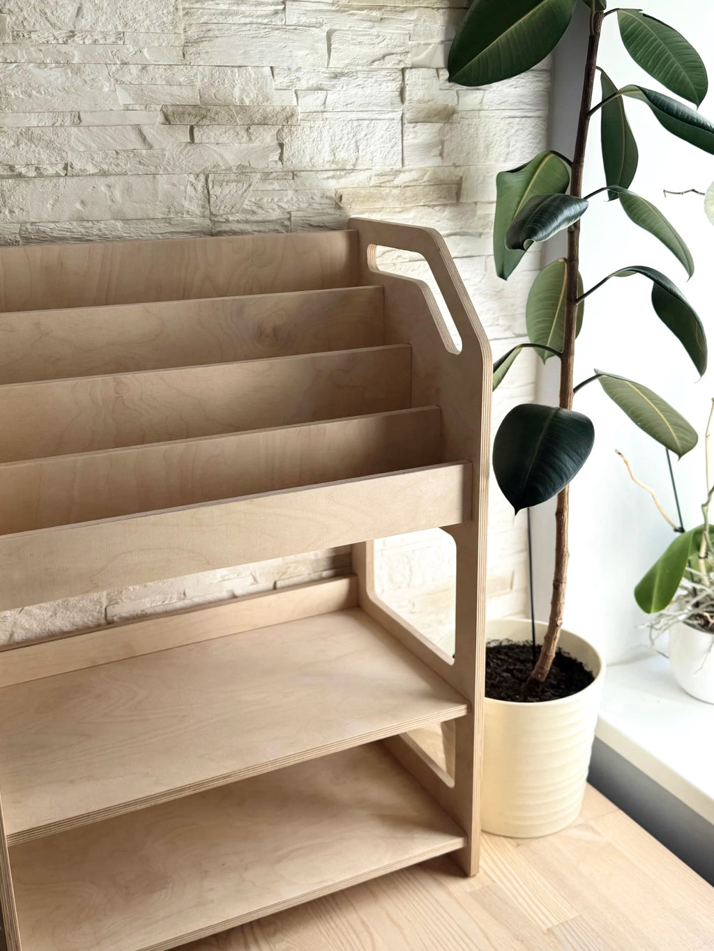 montessori bookshelf in a sunlit nursery with soft toys and books neatly arranged