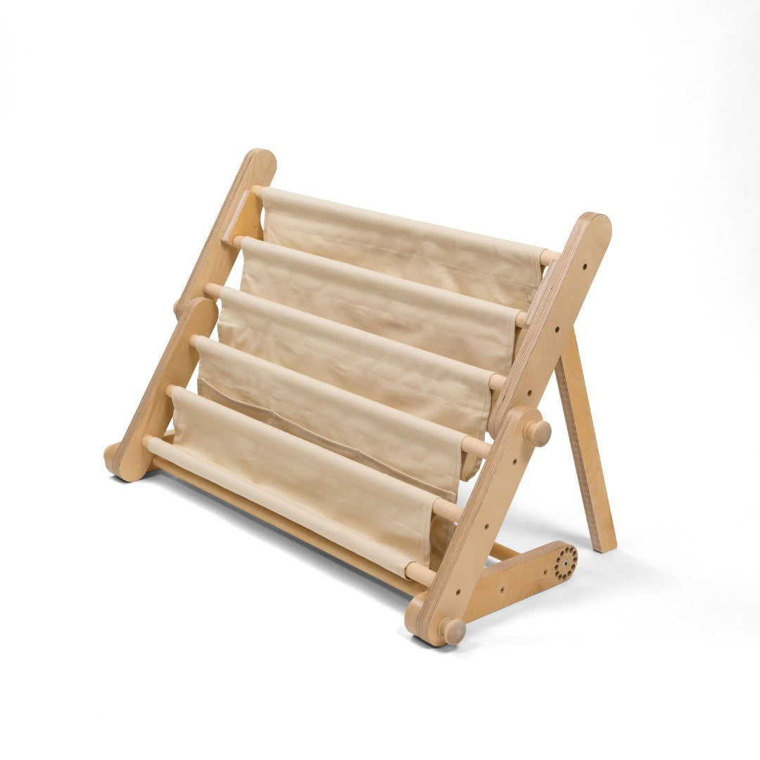 a playful montessori bookshelf attached to a play frame, bursting with colorful picture books in a sunlit playroom