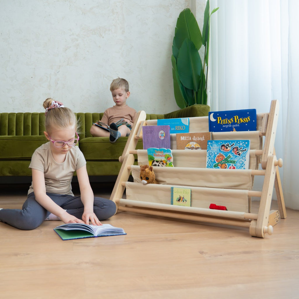 bold front-facing montessori bookshelf attached to a play frame with vibrant book covers