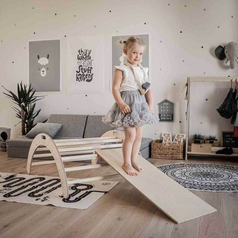confident child climbing the sturdy montessori arch in a bright playroom