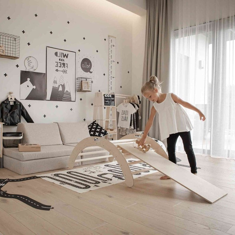 a child laughing while sliding down the wooden montessori arch ramp