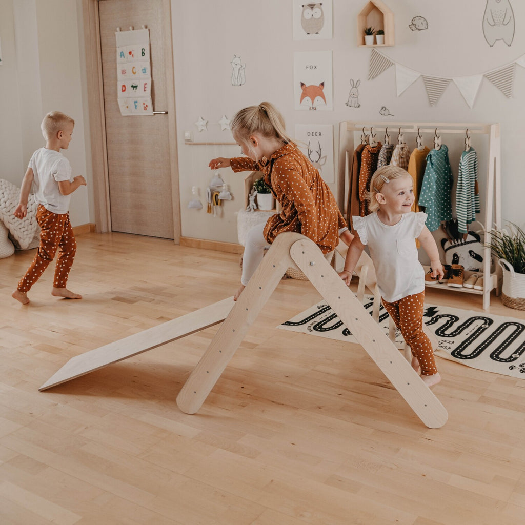 a toddler's joyful laugh while sliding down the birch plywood ramp on their montessori climber