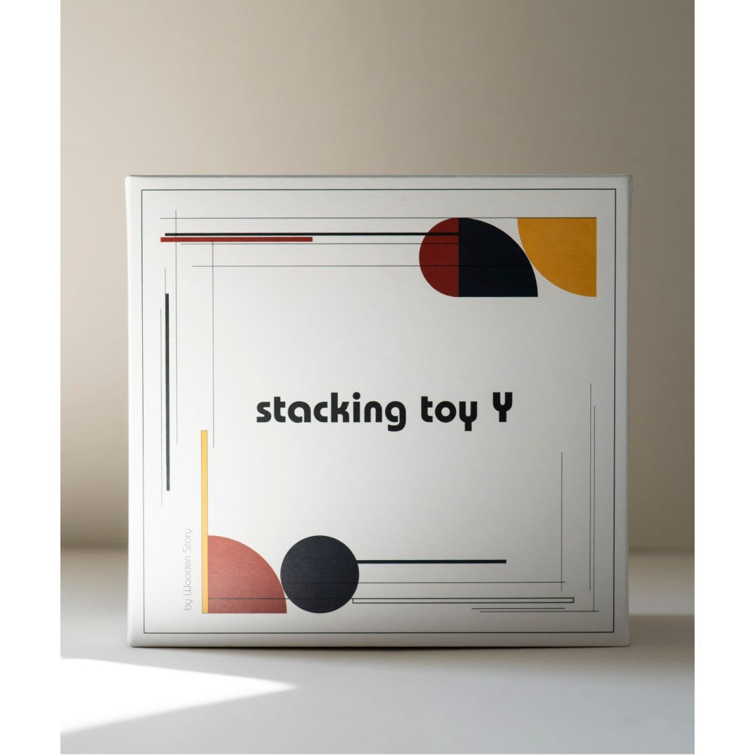 a child's hand stacking a brightly lit geometric wooden fence piece in playful disarray
