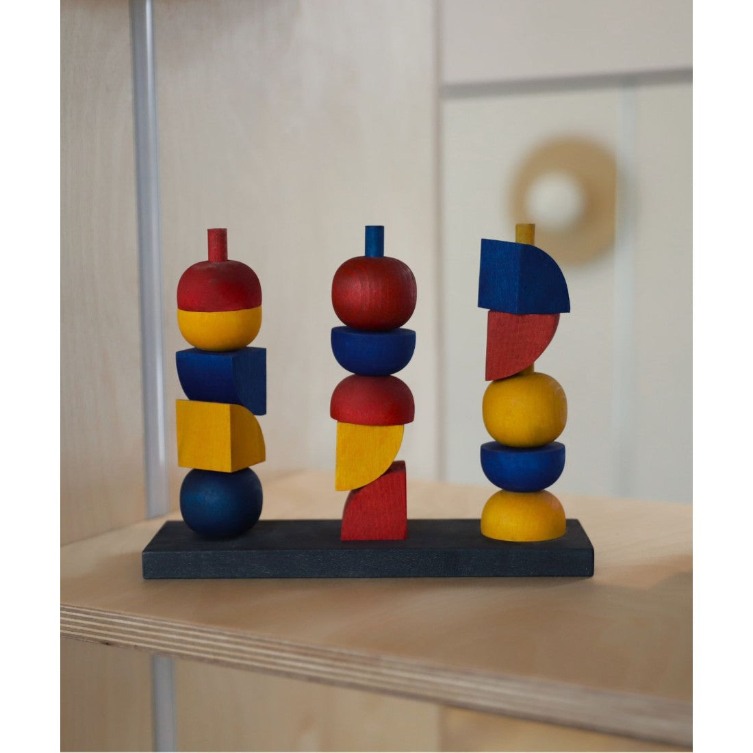 elegant wooden stacking toy arranged in a balanced tower on a minimalist table
