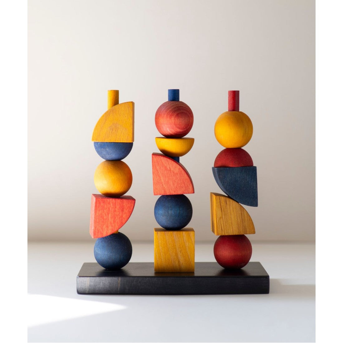 a bold close-up of the modern wooden stacking toy's geometric pieces in warm morning light