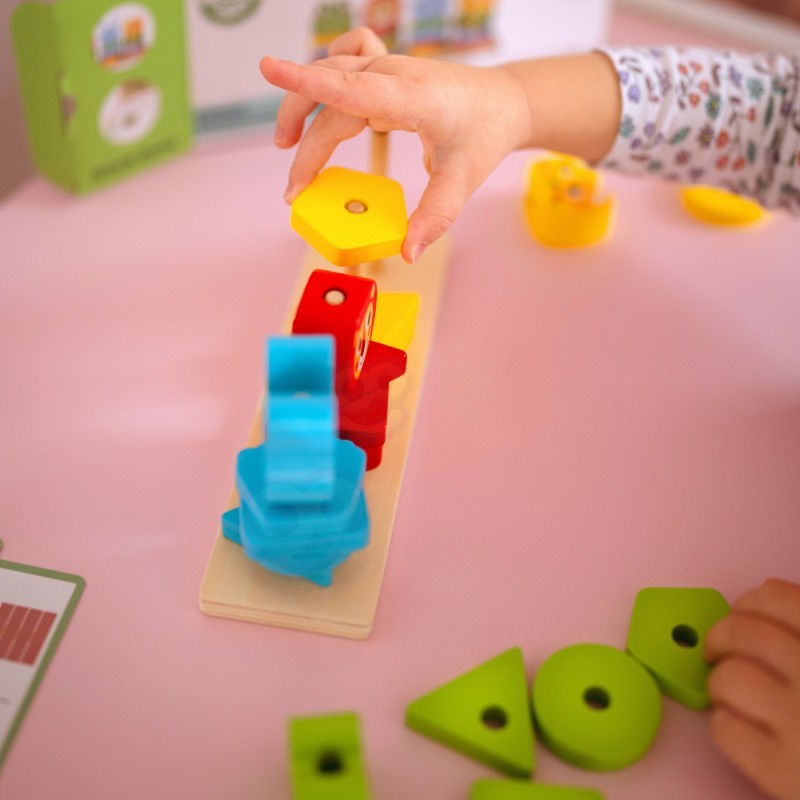 a child's small hands stacking the wooden animal puzzle pyramid on a sunlit wooden table
