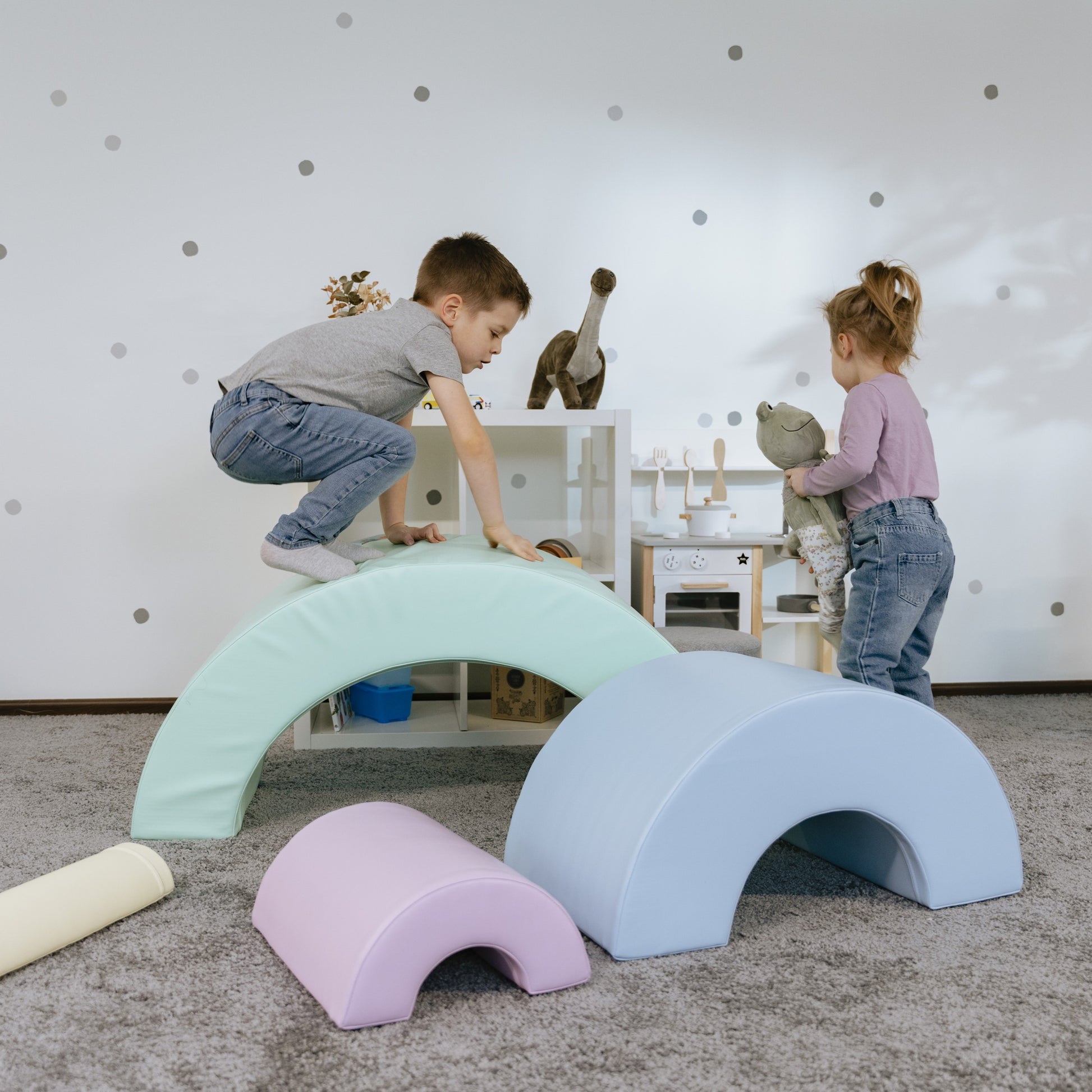 a child's hand building a vibrant montessori rainbow soft play set castle