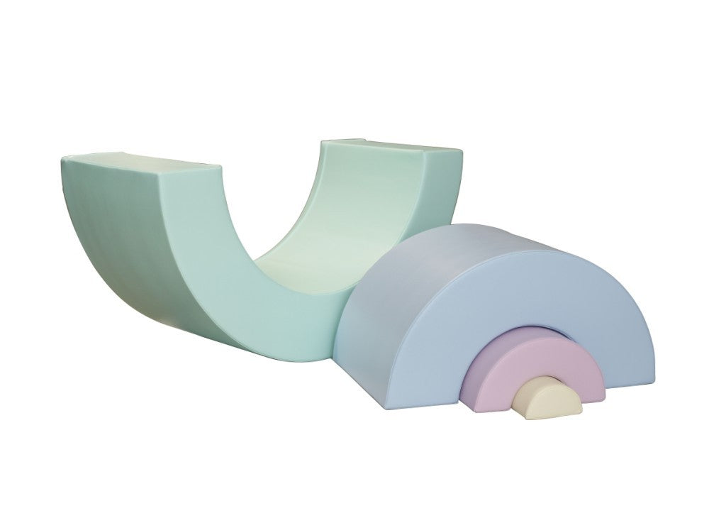 a child's hand building a vibrant montessori rainbow soft play iglu block tower