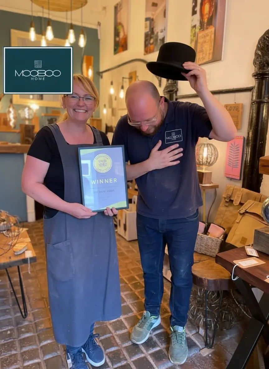 Two people in a store with one holding an award, featuring the Mooboo Home brand logo on sostter.pro