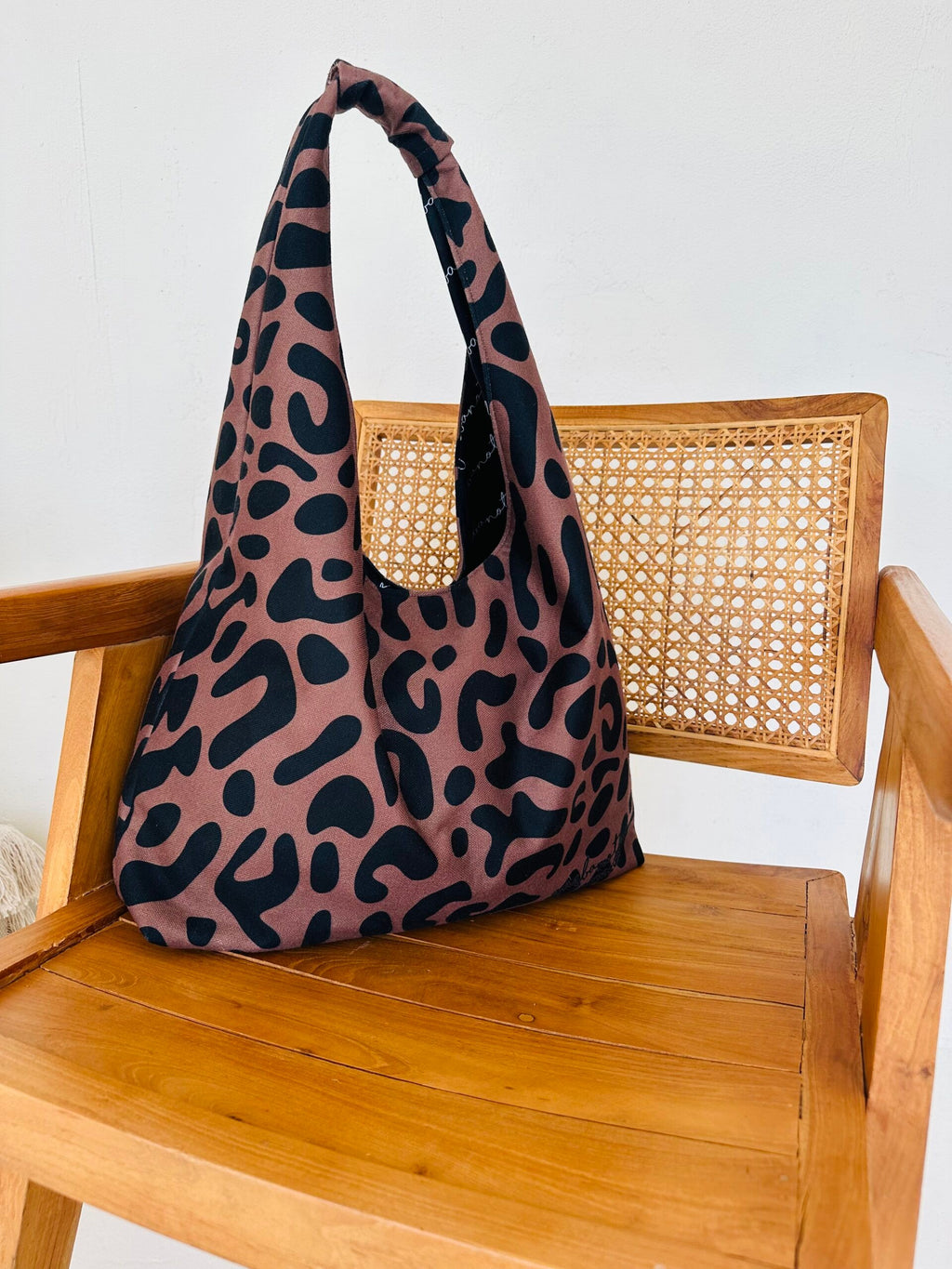 a functional leopard print moon bag with its interior garbanota lining and zippered pocket on display