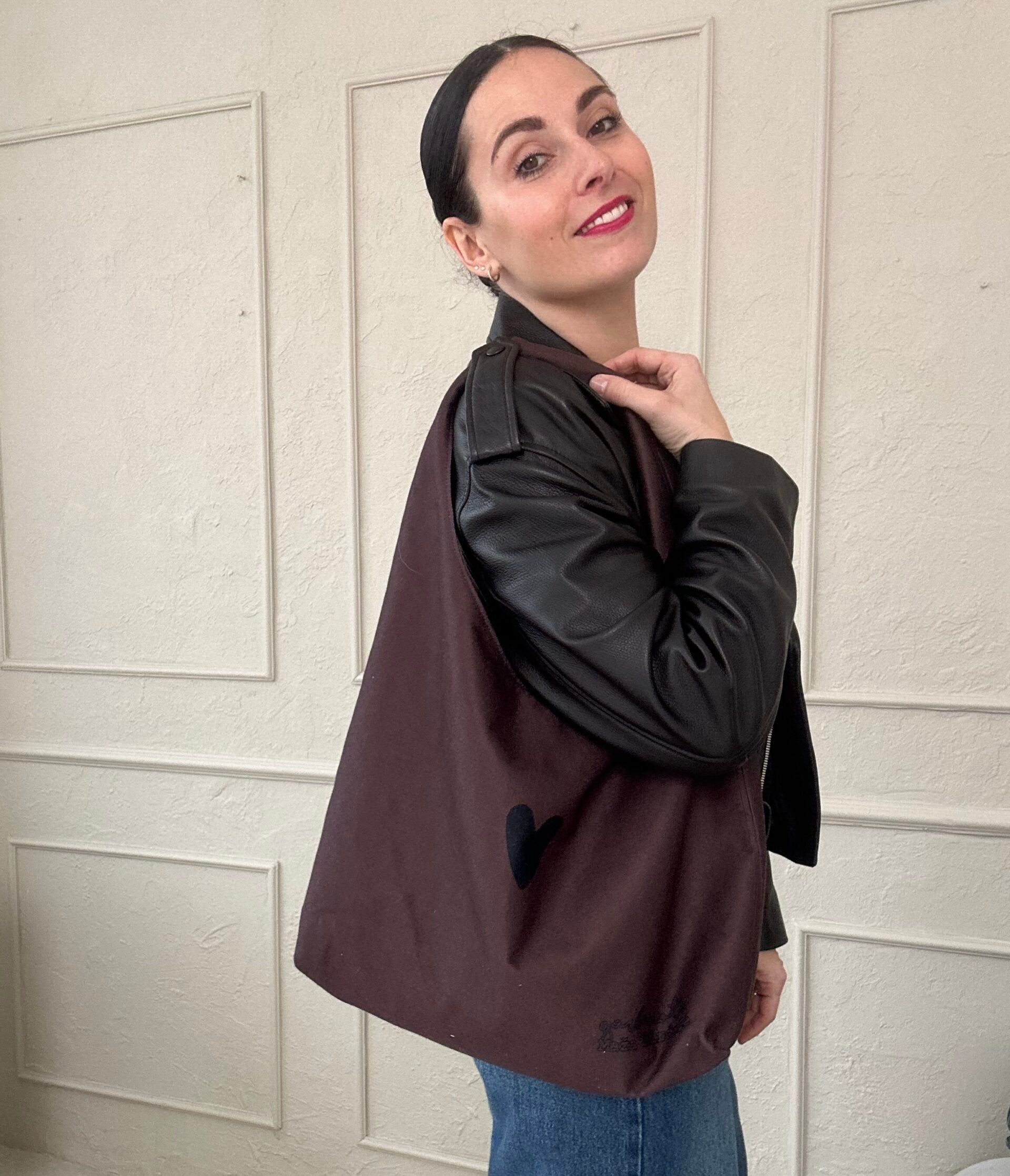 confident woman showcasing a brown moon bag heart shoulder bag with a bold, spacious design