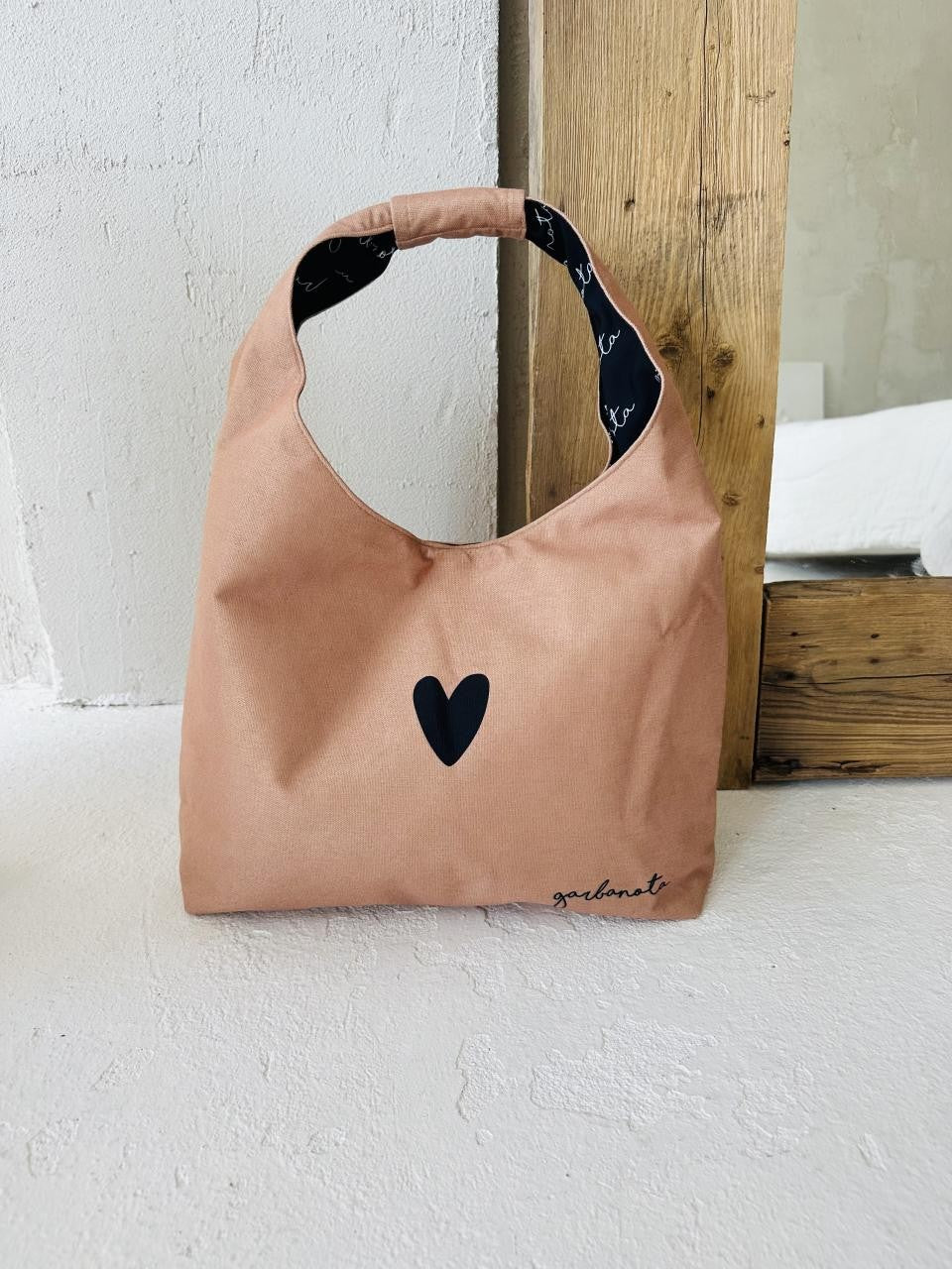 elegant cream moon bag heart on a minimalist background, highlighting its refined shape and premium lithuanian craftsmanship