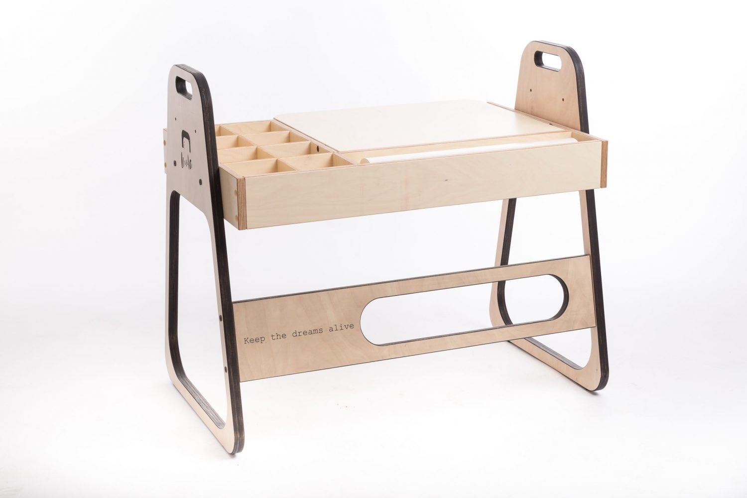 a child laughing while drawing on the julle art table with the paper roll in a sunlit playroom