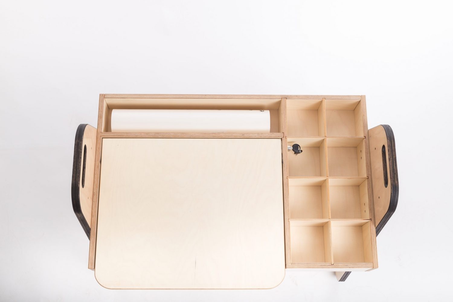 a child's hands drawing on the julle art table with the paper roll and side storage boxes in view