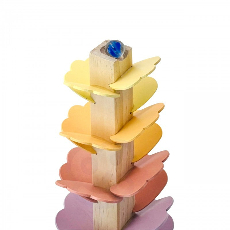 a child's hand guiding a pastel ball down the musical rainbow track