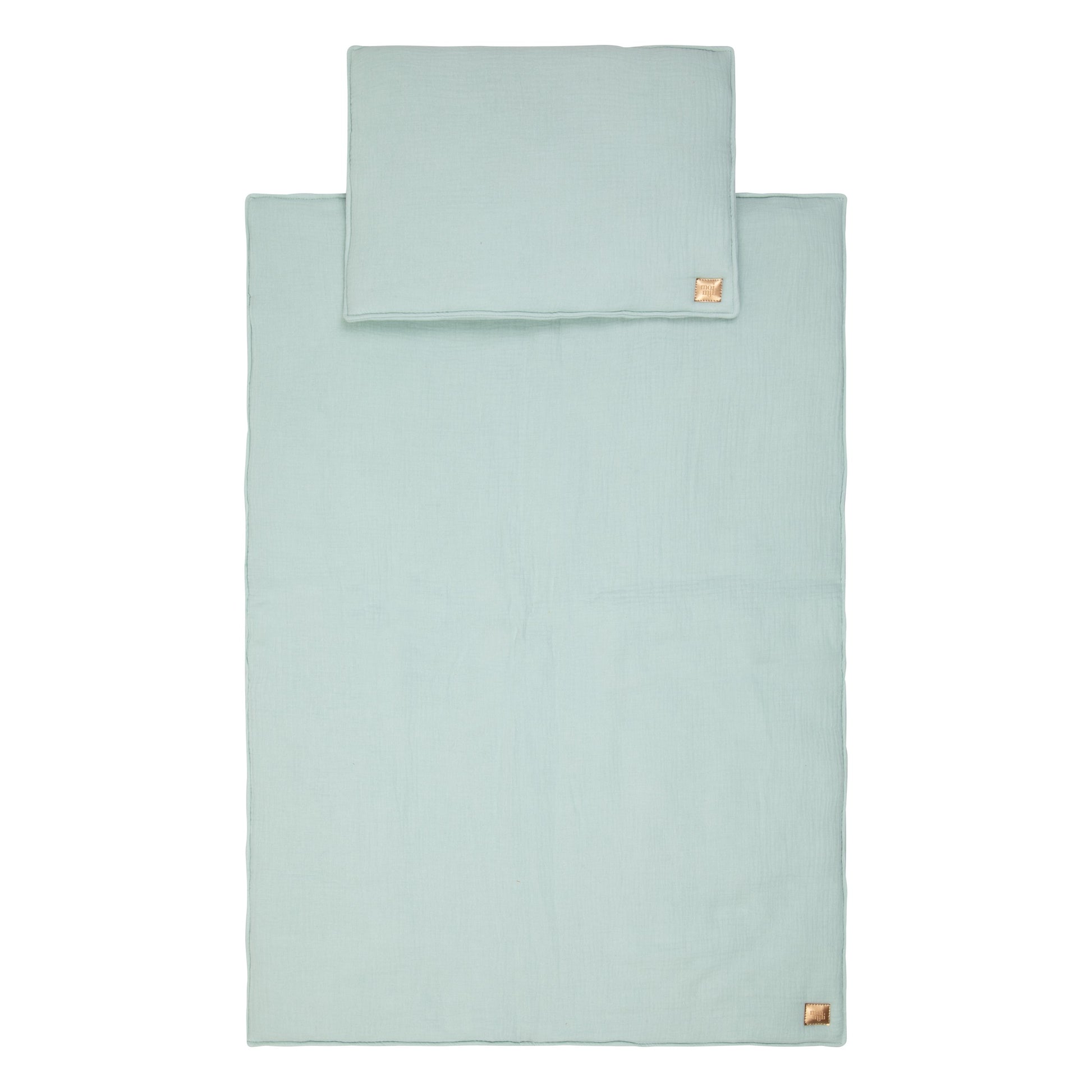 mint muslin baby blanket and pillow set laid out on a soft, neutral background, showcasing its gentle texture and handmade quality