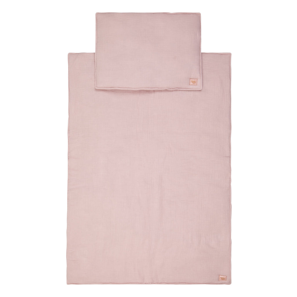 bold baby pink muslin blanket and pillow set laid flat on a clean surface, showcasing its full size and artisan quality