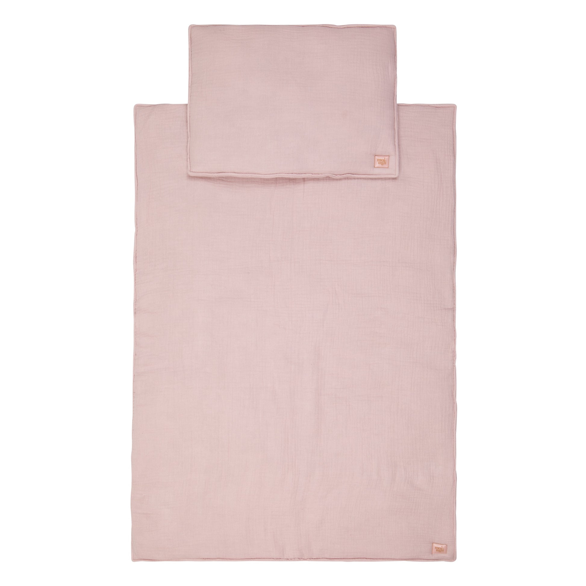 bold baby pink muslin blanket and pillow set laid flat on a clean surface, showcasing its full size and artisan quality