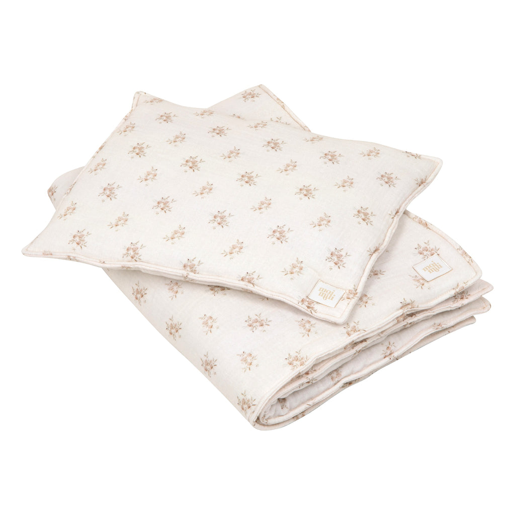playful boho flower muslin baby blanket and pillow set laid on a sunny nursery rug, ready for cozy naps