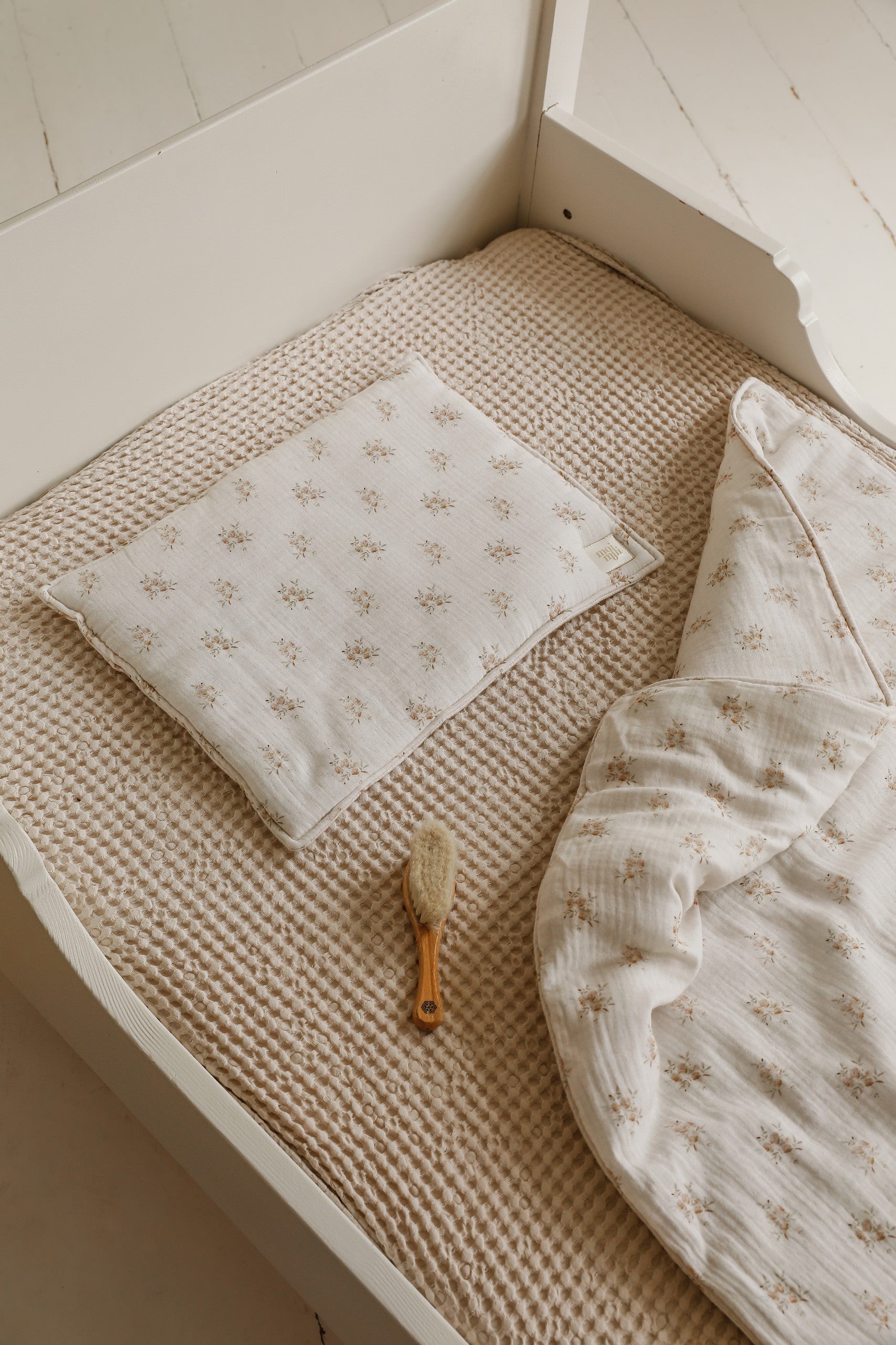 soft boho flower muslin baby blanket and pillow set draped over a cozy nursery chair, gentle and airy for delicate skin