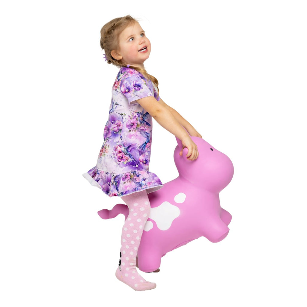 a bold pink cow hoppy toy for kids on a bright playroom floor