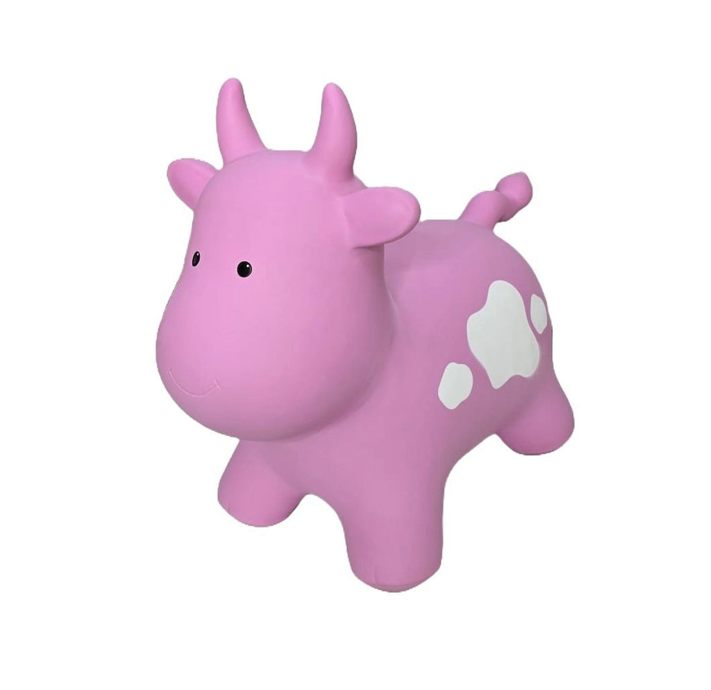 a soft pink cow jumpy toy sitting gently on a cozy nursery rug