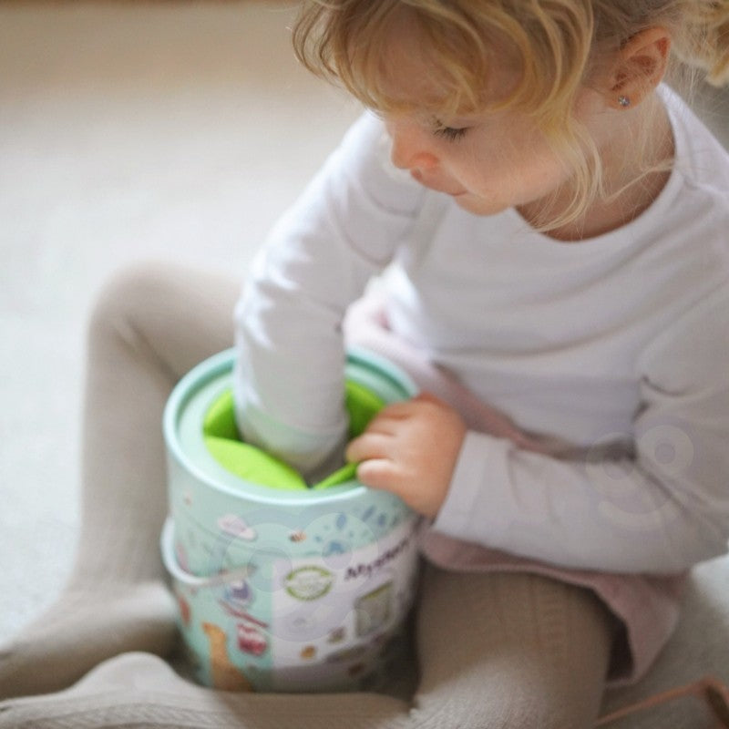 elegant close-up of a child's hand feeling a smooth wooden shape inside the dark mystery box