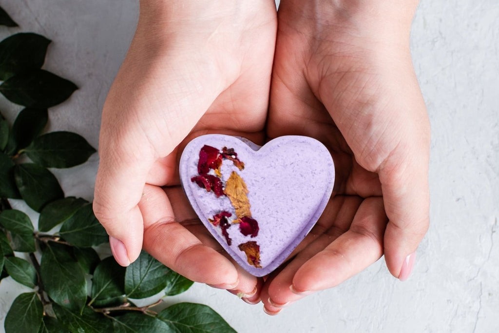 close-up of five lavender heart shower steamers arranged on a bathroom countertop
