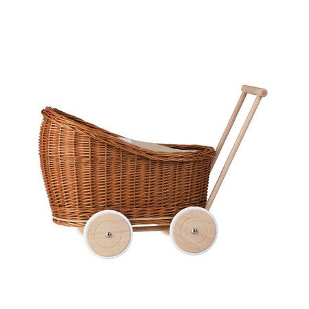 bold front view of a natural wicker doll pram with beige bedding in dramatic studio lighting