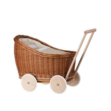 close-up of the natural wicker doll pram luna with soft beige bedding and pillow