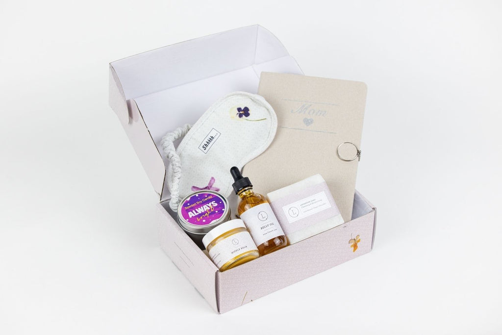 softly lit pregnancy gift box with lavender soap and a cozy eye mask on a comforting linen backdrop