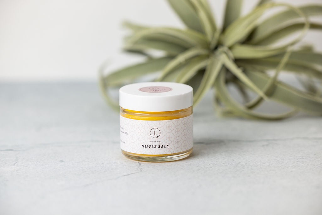 playful close-up of organic nipple balm jar with a tiny flower on top