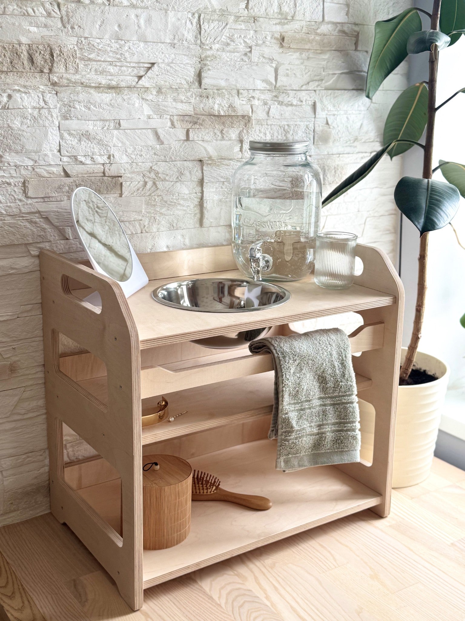 a child's wooden washbasin with enamel bowl, shown in warm morning light on a contemporary leather bag background