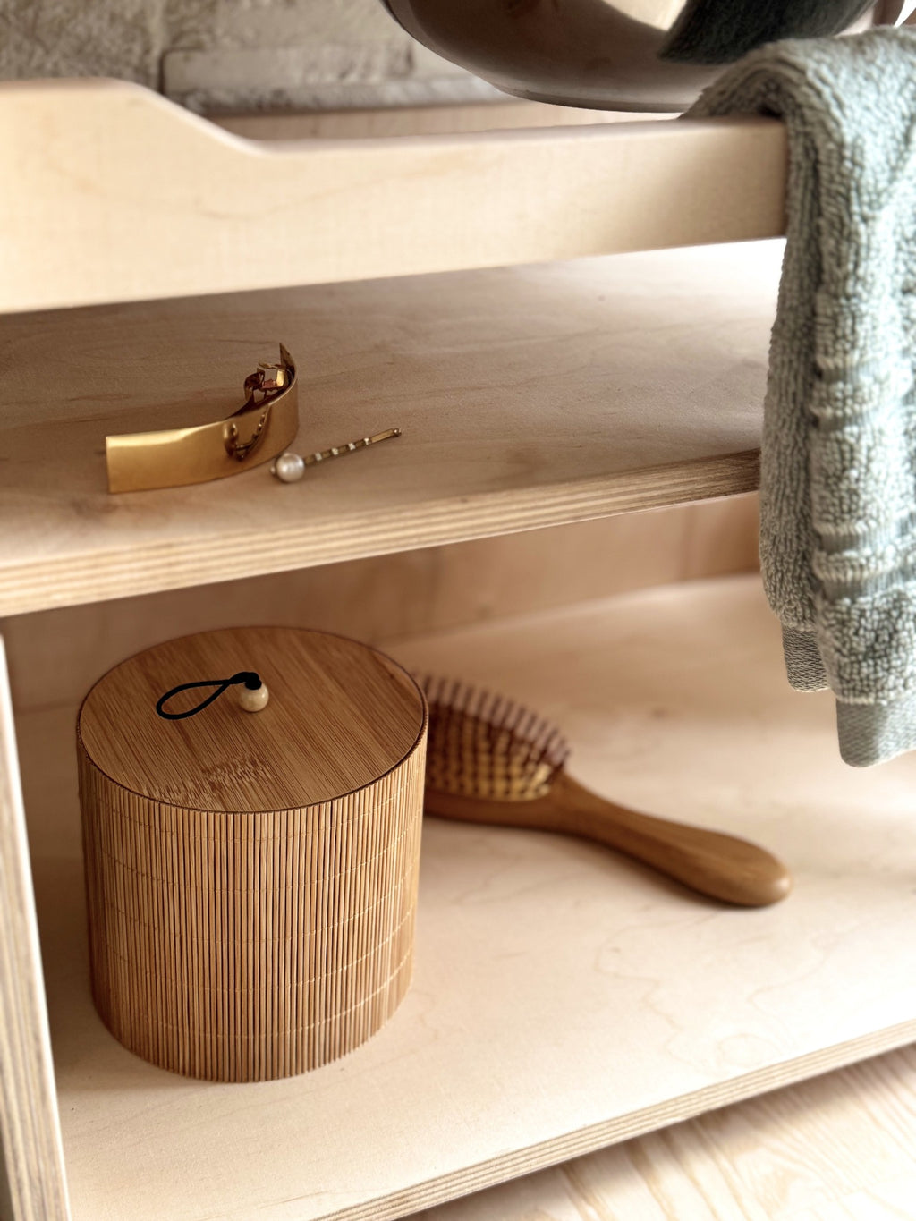 elegant latvian-made wooden washbasin for children, shown in soft morning light with a leather accessory nearby