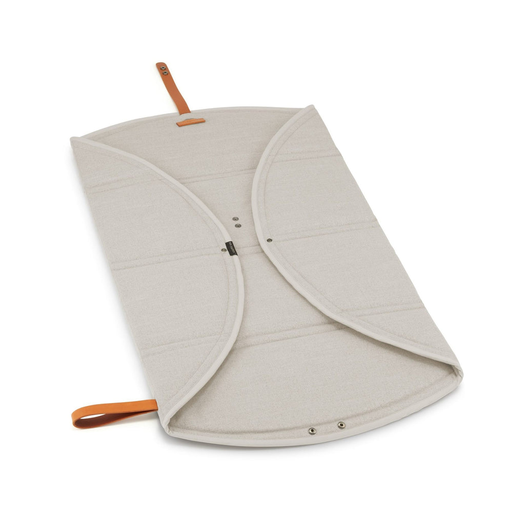 a playful beige dog travel mat with a stylish leather belt, ready for a fun adventure