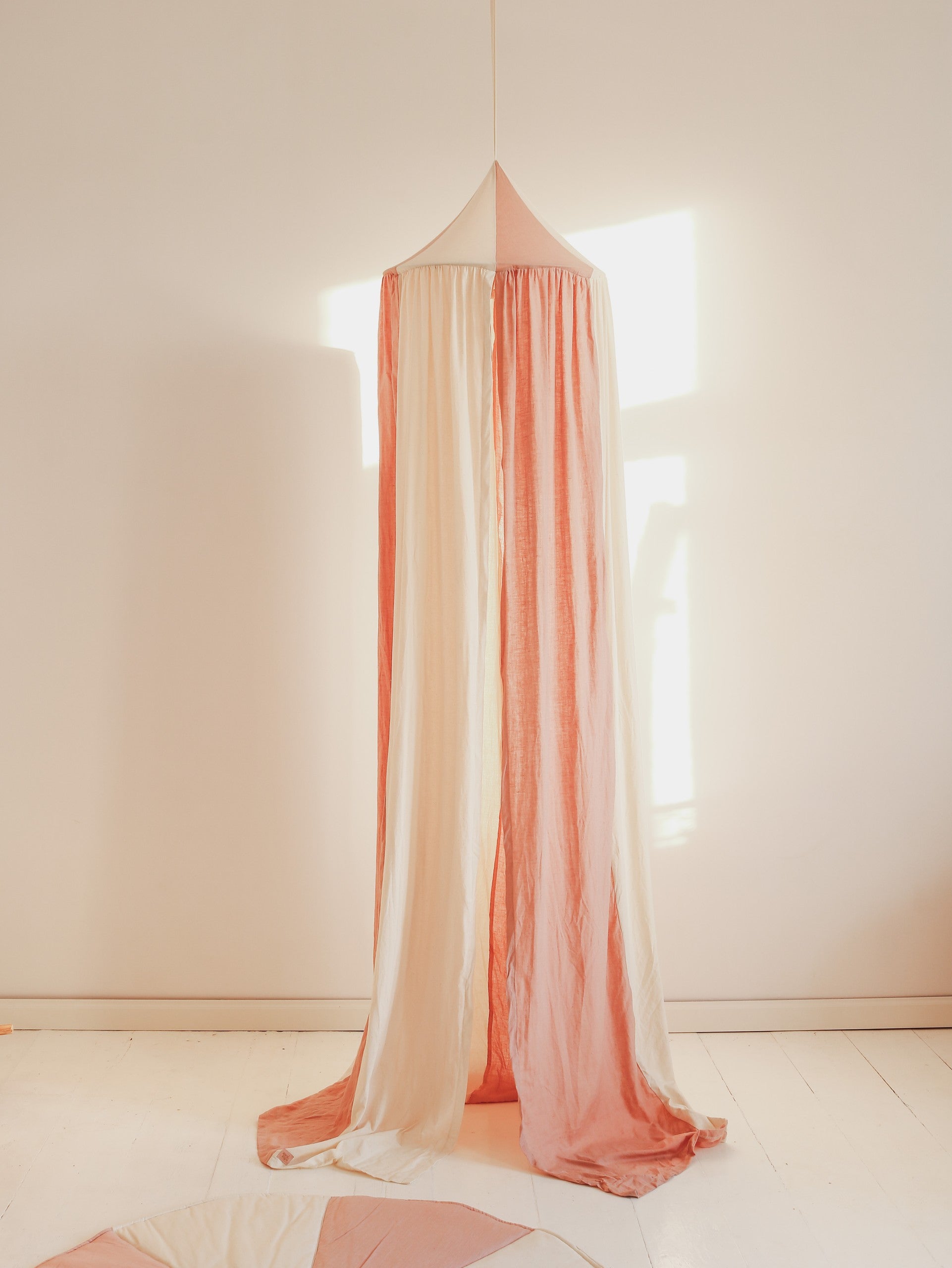 bold powder pink organic cotton linen canopy hanging over a childs bed as a dreamy hideaway