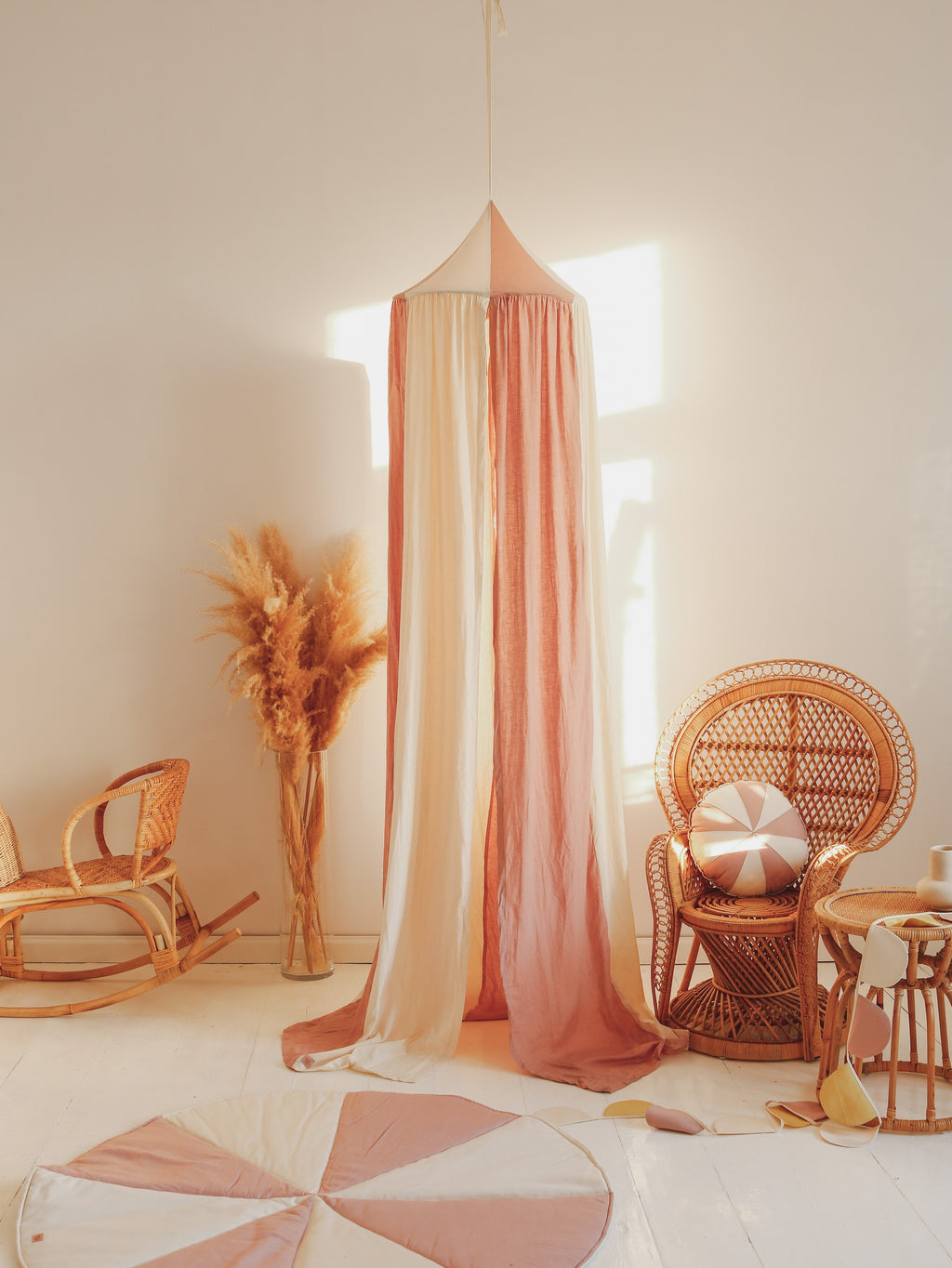 powder pink linen and cotton kids canopy in a sunlit garden nook with soft draped fabric
