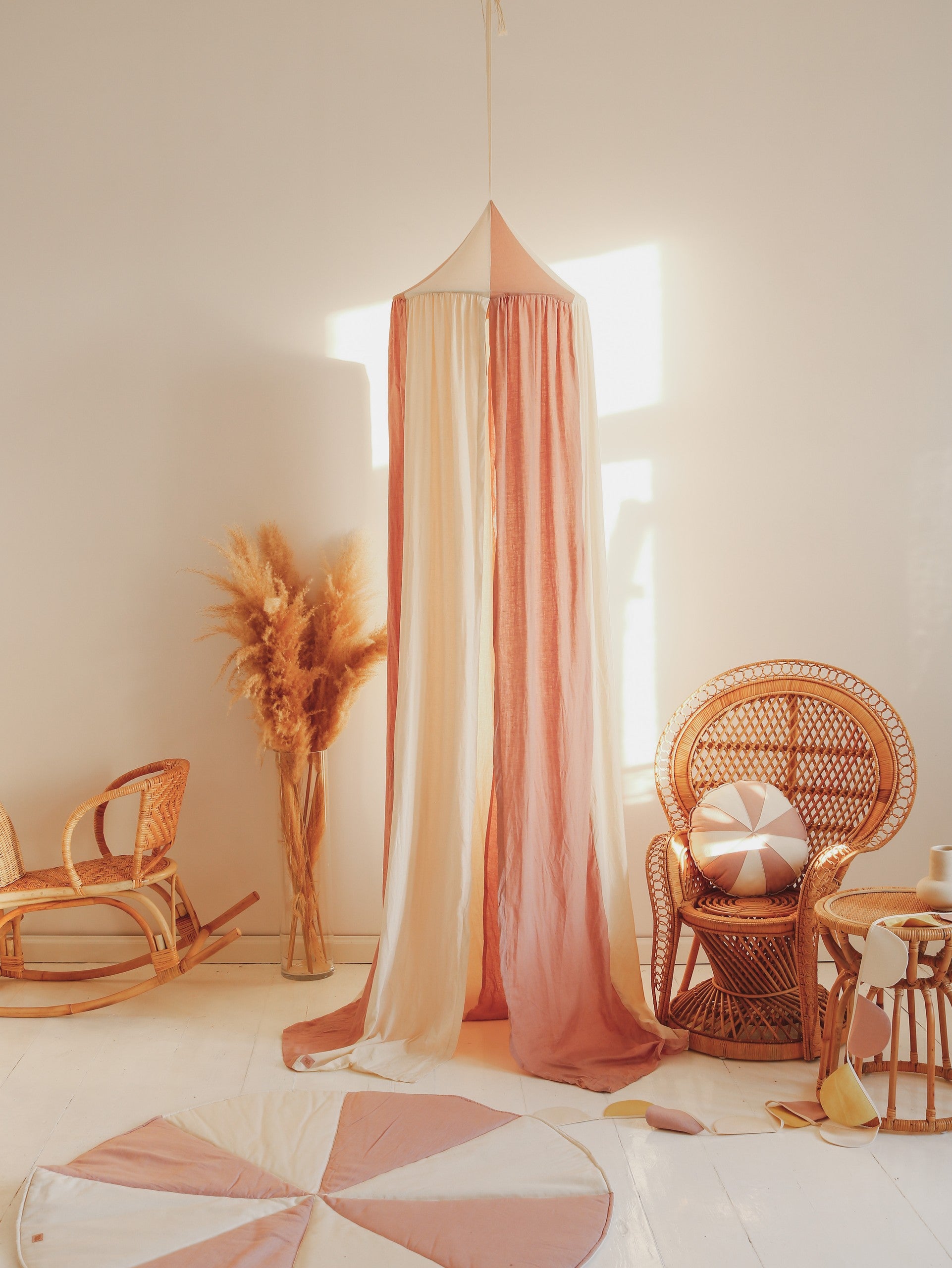 powder pink linen and cotton kids canopy in a sunlit garden nook with soft draped fabric