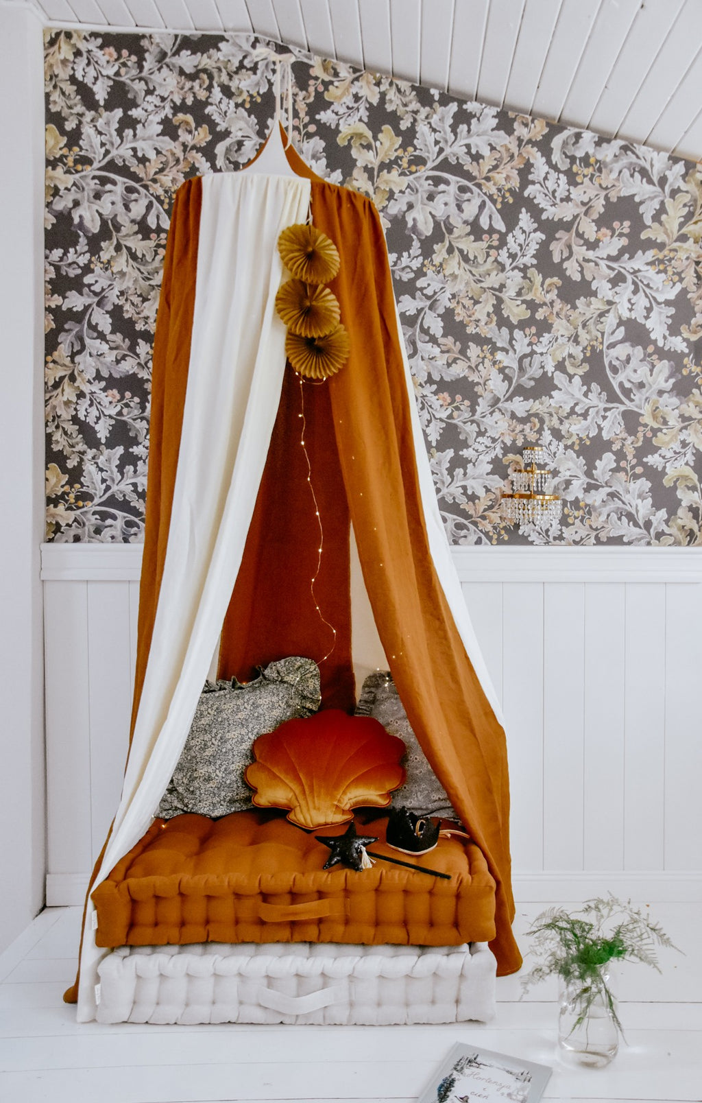 organic cotton and linen canopy in warm caramel tones, hung over a child's bed with soft morning light